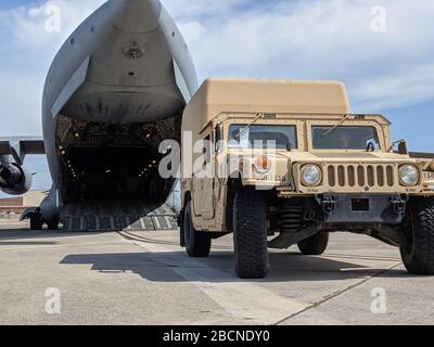 Soldati di un'azienda, 63rd Expeditionary Signal Battalion, 35th Signal Brigade assegnato a Fort Stewart, Georgia. Spostare i loro veicoli su un aereo all'Hunter Army Airfield, 4 aprile 2020. Il 63rd ESB è costituito da personale e apparecchiature mobili a supporto del comando nordico degli Stati Uniti e della richiesta di supporto da parte dell'esercito statunitense Nord per la difesa delle autorità civili in risposta alla pandemia del COVID-19, fornendo supporto per le comunicazioni alle aree interessate dal COVID-19. (STATI UNITI Foto dell'esercito del personale Sgt. Joseph Truckley) Foto Stock