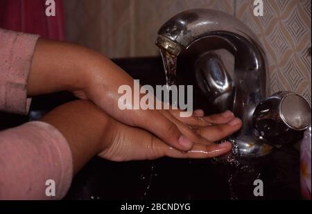 Un bambino indiano che lava le mani nel lavabo o per proteggere contro Corona Virus o Covid 19 Foto Stock