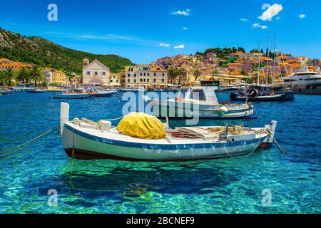 Popolare resort mediterraneo con porto e citta' vecchia. Yacht di lusso e barche da pesca ormeggiate nel porto di Hvar, isola di Hvar, Dalmazia, Croazia, EUR Foto Stock