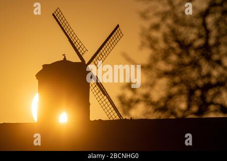 Il sole sorge su Chesterton Windmill nel Warwickshire. Foto Stock