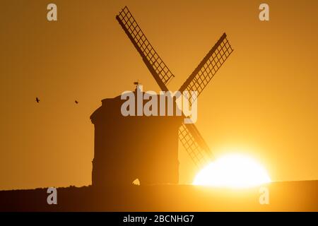Il sole sorge su Chesterton Windmill nel Warwickshire. Foto Stock