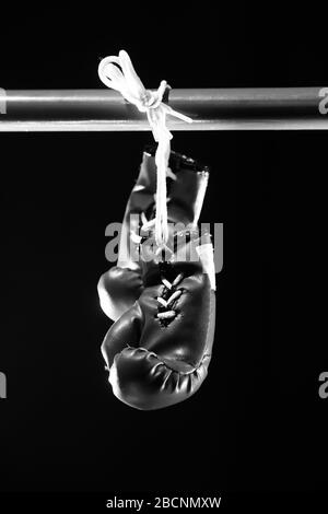 Guanti da boxe rossi su fondo di gocce d'acqua. Stile di vita sportivo. Motivazione. Raggiungimento dell'obiettivo. Proteggetevi. Bianco e nero Foto Stock