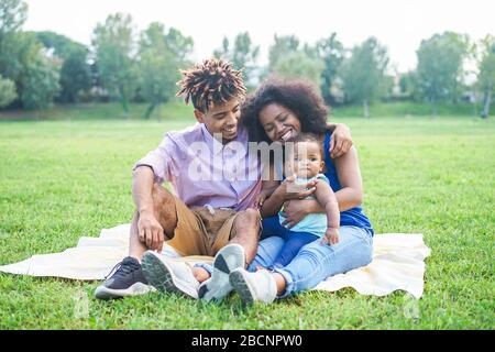 Felice famiglia nera divertirsi facendo pic-nic all'aperto - Genitori e loro figlia godendo il tempo insieme in un giorno di fine settimana - Love teneri momenti e happ Foto Stock