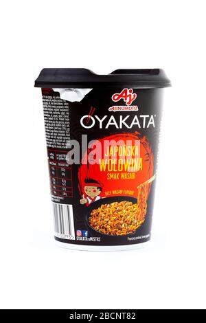 Una tazza di plastica di Ajinomoto Oyakata giapponese di manzo aromatizzato istantanea, tagliatelle in un contenitore nero su bianco, oggetto tagliato, descrizione polacca Foto Stock