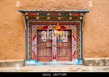 Porta di stile tibetano su un edificio nel villaggio di Malong, provincia di Sichuan, Cina. Foto Stock