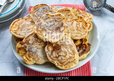 Soffici pancake fatti in casa con mela spolverata con zucchero a velo Foto Stock