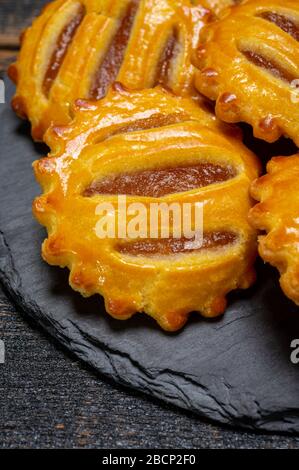 Biscotti appena sfornati, piccoli e rotondi, riempiti con marmellata di mele da vicino Foto Stock