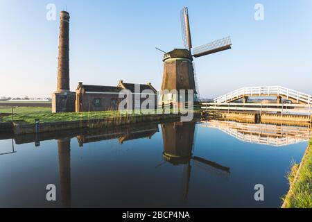 Il mulino a vento De Kaagmolen di fronte a un canale e barca, Olanda del Nord, Paesi Bassi Foto Stock