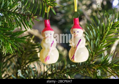 Due snowmen-nuovi anni sovietico vetro di Natale giocattoli albero su un ramo di abete verde Foto Stock