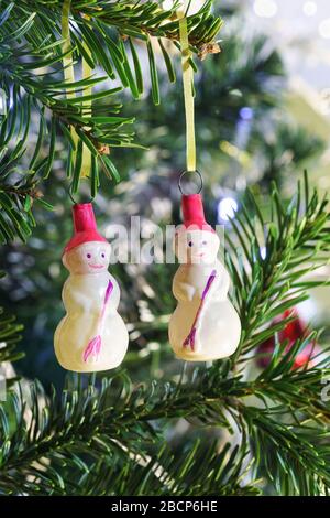 Due snowmen-nuovi anni sovietico vetro di Natale giocattoli albero appeso su un ramo di abete verde Foto Stock