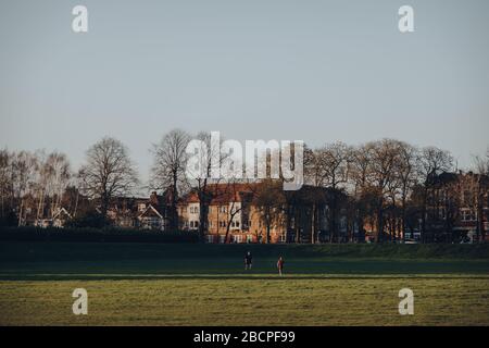 Londra, Regno Unito - 22 marzo 2020: Vista a distanza di due persone che giocano a palla a Broomfield Park, parco pubblico a Palmers Green nel London Borough of Enfield Foto Stock