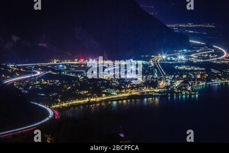 I sentieri delle luci e le luci notturne della città creano un bellissimo colore intorno a Losanna, in Svizzera, mentre la notte cade. Foto Stock