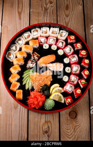 grande set di sushi colorato su un piatto rotondo. su uno sfondo di legno Foto Stock