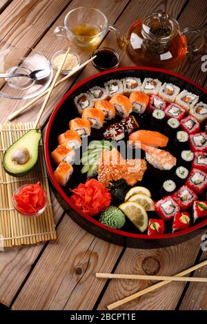 grande set di sushi colorato su un piatto rotondo. su uno sfondo di legno Foto Stock