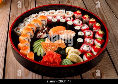grande set di sushi colorato su un piatto rotondo. su uno sfondo di legno Foto Stock