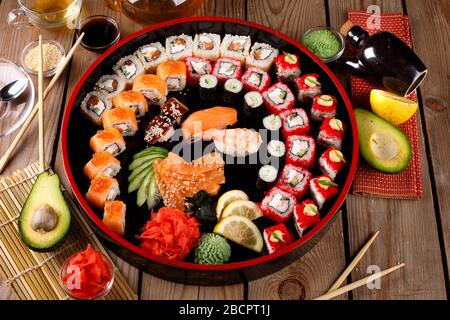 grande set di sushi colorato su un piatto rotondo. su uno sfondo di legno Foto Stock