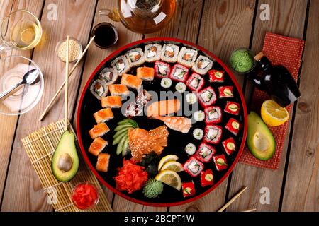 grande set di sushi colorato su un piatto rotondo. su uno sfondo di legno Foto Stock