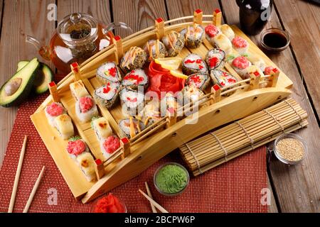 grande set di sushi colorato in un piatto quadrato. su uno sfondo di legno Foto Stock