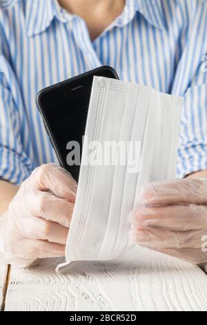 Pulizia del telefono cellulare per eliminare i germi, Covid-19 utilizzando lana di cotone con alcol per pulire per evitare di contaminare con il virus Corona Foto Stock