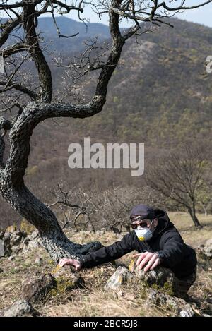 Uomo che fa sport in natura in maschera chirurgica facciale, coronavirus pandemico. E' sicuro all'esterno nella natura durante la pandemia COVID-19. Foto Stock