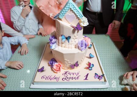 Ci sono farfalle e una torta in cima. Il numero uno sulla torta di casa rosa . Foto Stock