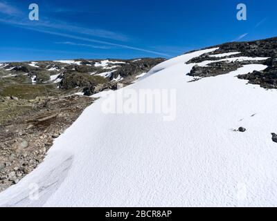 La neve si trova sulle montagne ai lati della strada di montagna Aurlandsvegen, Aurland, Norvegia Foto Stock