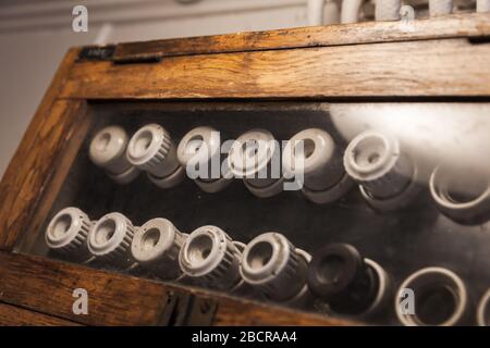 Fusibili elettrici vintage montati su un pannello scuro in una custodia di legno Foto Stock