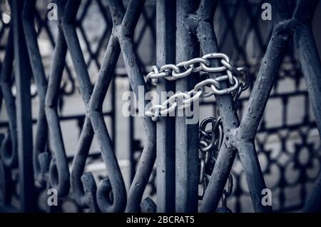 Catena su un cancello metallico. I cancelli massicci sono chiusi dall'interno con un lucchetto con una catena robusta. Vista laterale. Messa a fuoco selettiva.primo piano. Senza peopl Foto Stock