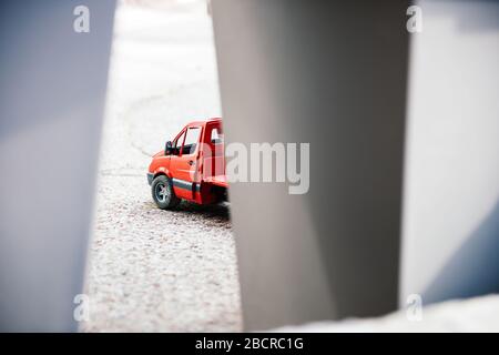 Vista attraverso le pareti di carta astratta di un furgone da costruzione rosso giocattolo Foto Stock