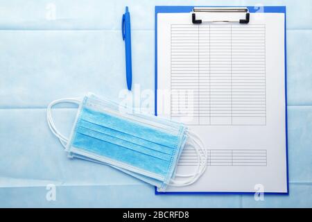 Elenco dei pazienti, modulo di prova con maschere igieniche mediche, documenti medici sul posto di lavoro dei medici in clinica. Nomina del medico. Medicina concettuale Foto Stock