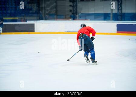 Giocatore professionista di hockey su ghiaccio in rosso sul ghiaccio Foto Stock