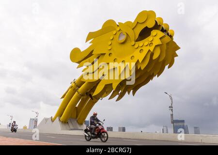Pilota di motocicletta che passa la testa del Ponte del Drago (Cầu Rồng) sopra il fiume Han a Da Nang, Vietnam. Foto Stock