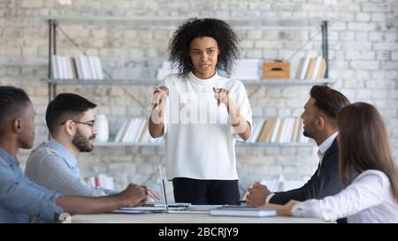 Il responsabile di una donna d'affari africana e americana parla nella sala del consiglio di amministrazione durante la riunione. Foto Stock