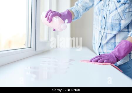 Ritratto corto di donna irriconoscibile lavando le finestre durante la pulizia della molla, fuoco sulle mani femminili che portano i guanti dentellare, spazio della copia Foto Stock