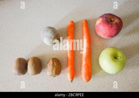 Verdure biologiche e frutta poste sopra una cucina preparata per un pasto di insalata salutare e un frullato Foto Stock