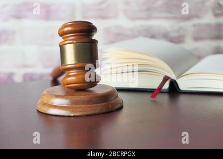 Primo piano del gavel e libro aperto sul tavolo Foto Stock