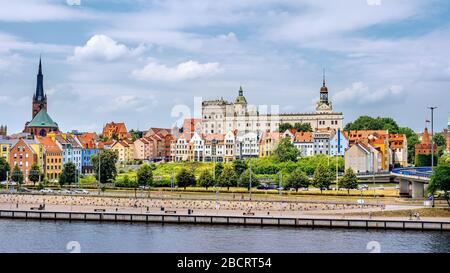 Persone che camminano su Piastowski Boulevard. Città vecchia, Castello dei Duchi Pomerani e Cattedrale Basilica di San Giacomo Apostolo sullo sfondo, Szczecin Foto Stock