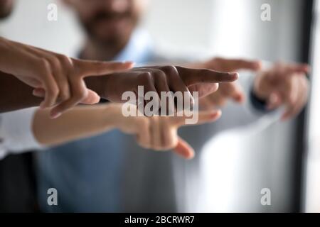 Diverse mani del team aziendale che mostrano le dita puntate verso l'obiettivo principale. Foto Stock