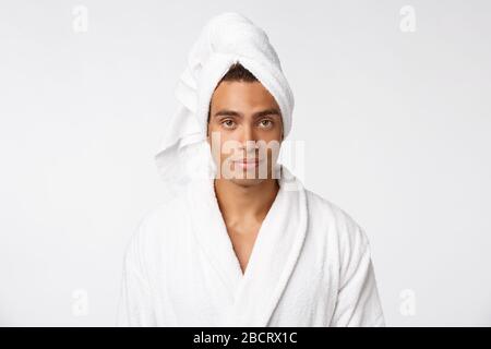 Ragazzo afro-americano che indossa un accappatoio con emozione felice. Isolato su sfondo whtie. Foto Stock