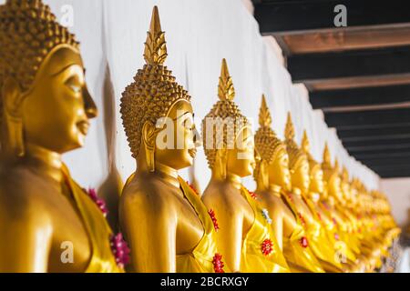 Le statue del Buddha d'oro seduti in fila a Wat Phutthaisawan, il Tempio del Buddha sdraiato Ayutthaya Thailandia Foto Stock
