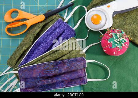 Maschere facciali cucite a mano in tessuto con utensili da cucire Foto Stock