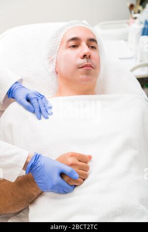 Primo piano della mano del medico che stringe la mano del paziente Foto Stock