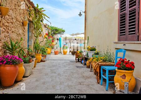 Marzameni, Italia. Una strada stretta tra le case colorate di un villaggio siciliano Foto Stock