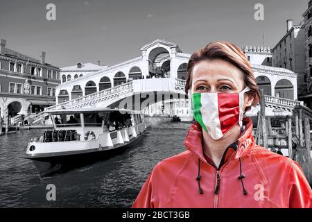 Donna con maschera facciale di protezione con bandiera italiana contro il coronavirus di fronte al ponte di Rialto, Venezia, Italia Foto Stock