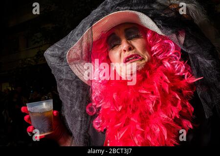 Donna, vestita con abiti lutto, con una parrucca rosa e piangente, che si sfilano per le strade durante la processione funeraria sepoltura delle Sardine Foto Stock