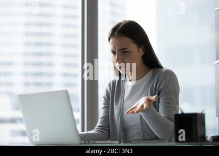 Dipendente femminile frustrato che ha problemi al computer sul luogo di lavoro Foto Stock