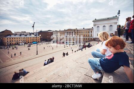 I piccoli turisti sono molto simpatici e si rilassano sulle scale della Cattedrale di Helsinki, sulla Piazza del Senato. Helsinki, Finlandia Foto Stock