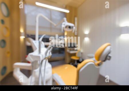 Vista offuscata della stanza dell'odontoiatria dei bambini con apparecchiatura professionale Foto Stock