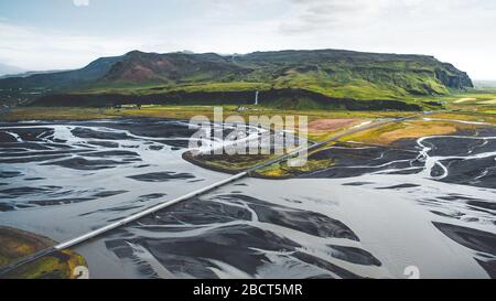 Vista sul drone della cascata Seljalandsfoss in estate con un enorme letto del fiume delta. Foto Stock