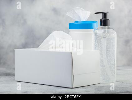 Contenitore in plastica con salviette imbevute di alcol con contenitore in plastica igienizzante per le mani e scatola di tessuti su sfondo bianco. Protezione ottimale da tutti i virus. Foto Stock